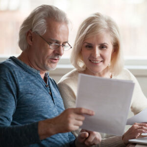 mychart A man and woman looking at some papers together and smiling.