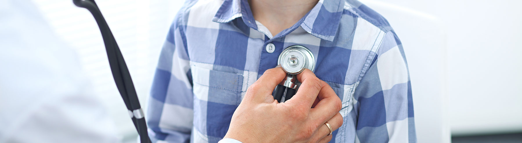 A doctor using a stethoscope on a young patient.