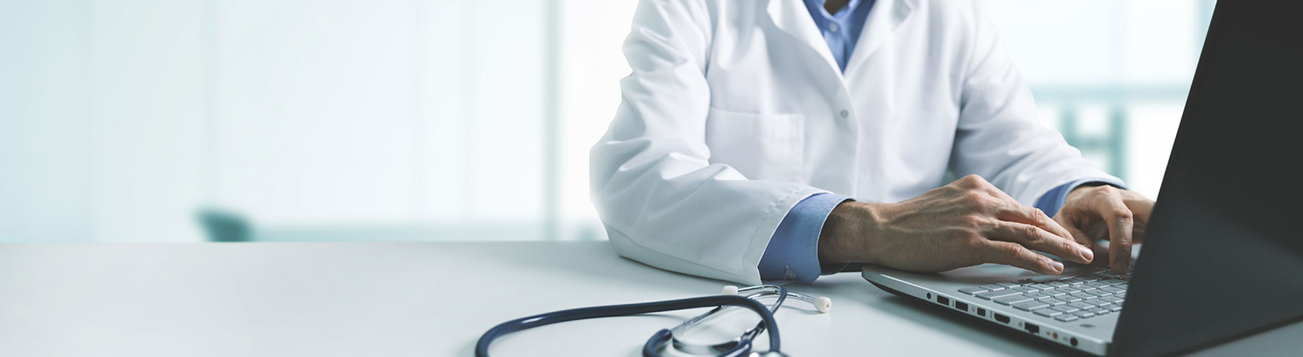 A doctor using a laptop computer.