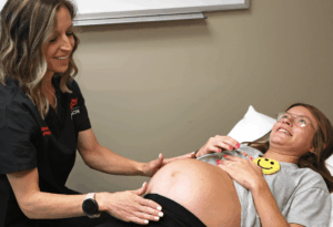A medical professional examining a pregnant woman.