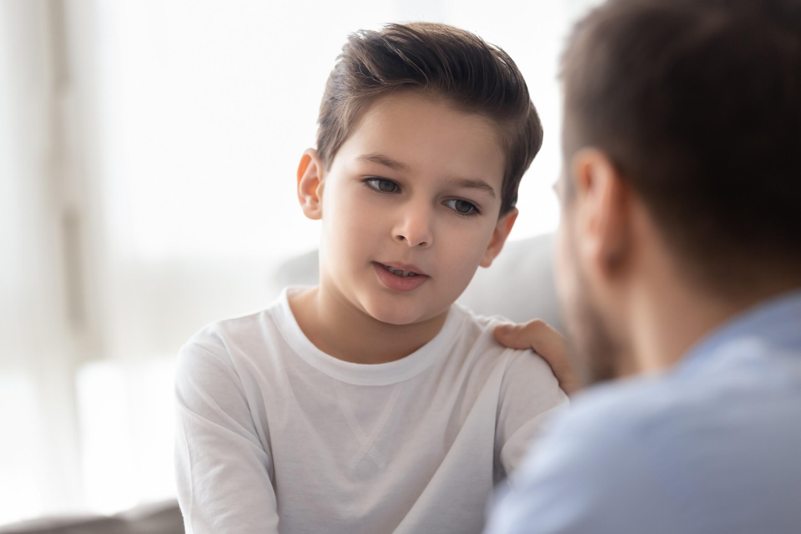 A young boy speaking with an adult.