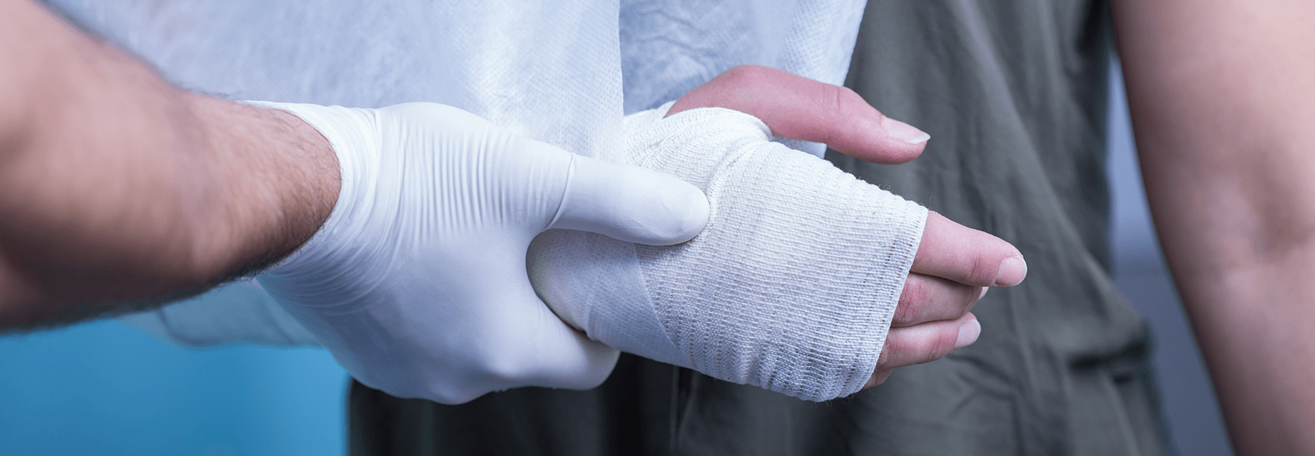 Doctor dressing a wound on a patient's hand.