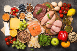 Healthy Foods A spread of healthy foods including fruits, vegetables, meats, cheeses, greens, grains, eggs, oil, and nuts.
